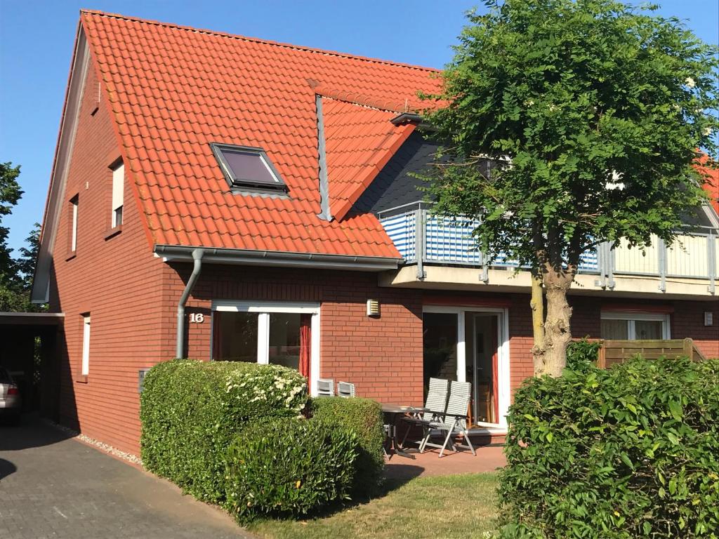 une maison en briques rouges avec un toit orange dans l'établissement Fewo Ostseetraum, à Kühlungsborn