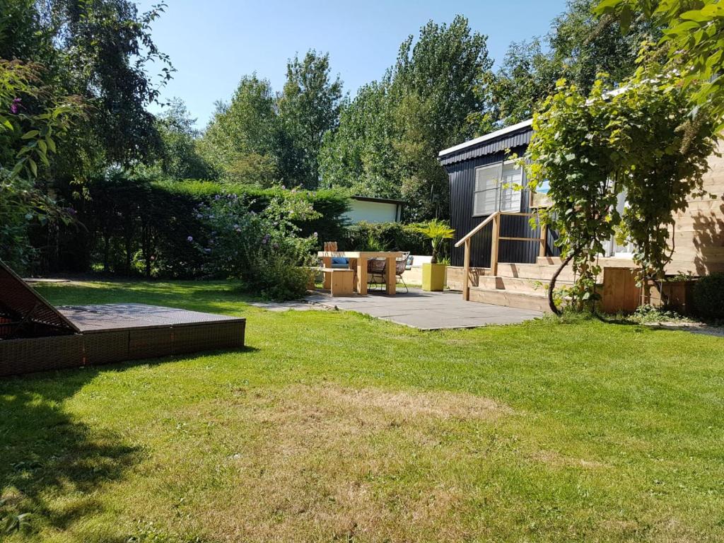 un jardín con una casa con patio en Zeeuwse Landhoeve en Brouwershaven