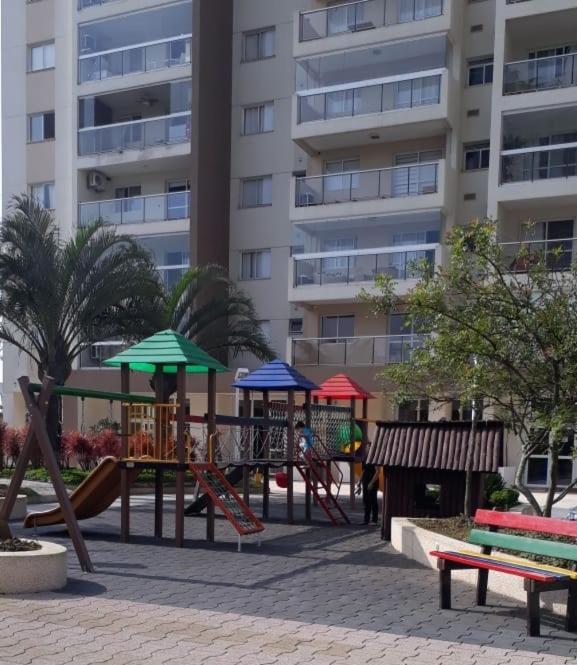 a playground in front of a large building at Ap 3 qtos 2vg gar cob Twice Guaruja in Guarujá
