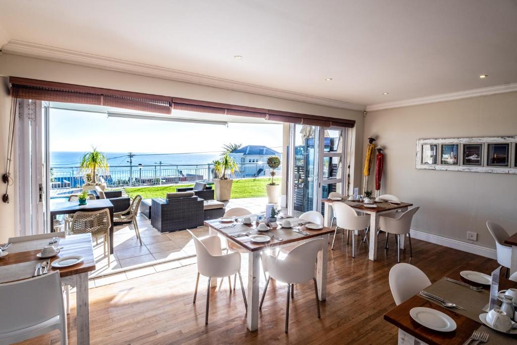 a dining room with a view of the ocean at 3 On Camps Bay in Cape Town