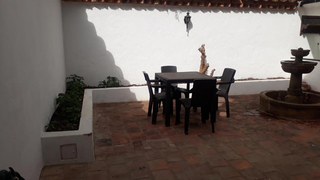 einen Tisch und Stühle in einer Terrasse mit einem Brunnen in der Unterkunft ALMANIK in Villa de Leyva