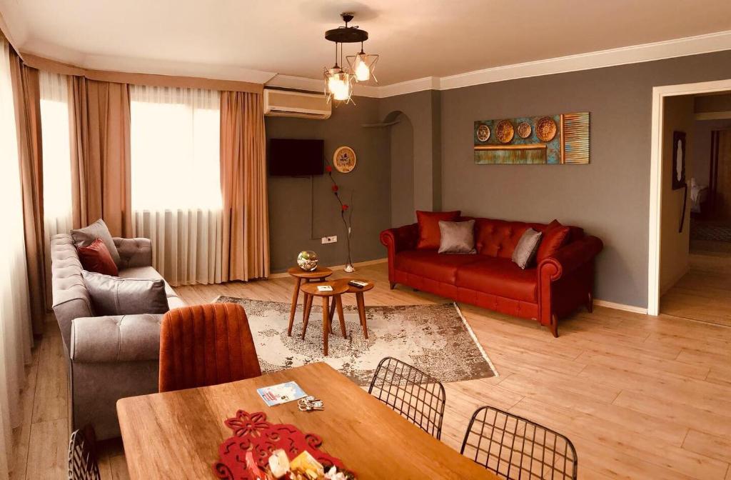 un soggiorno con divano rosso e tavolo di Sirena's Suites a Istanbul