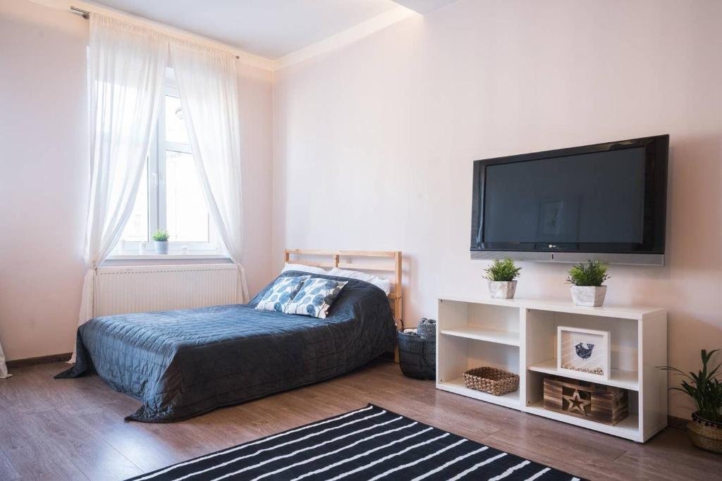 een slaapkamer met een bed en een flatscreen-tv bij Big Apartment - City Center - 70m2 - Nice Design in Wrocław