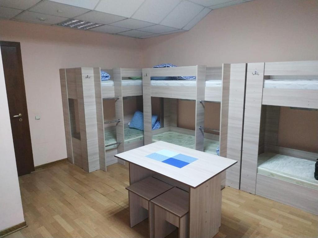 モスクワにあるHostel Legendarnyの二段ベッド4台とテーブルが備わる客室です。