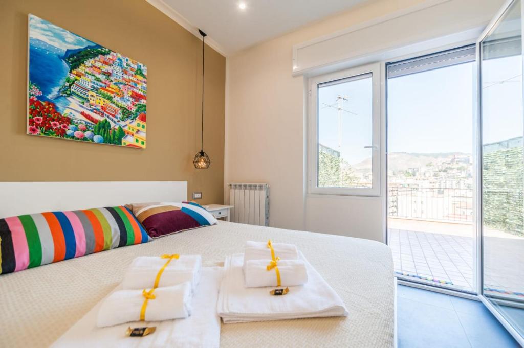 ein Schlafzimmer mit einem großen Bett und zwei Handtüchern in der Unterkunft Attico Oltremare B&B in Neapel