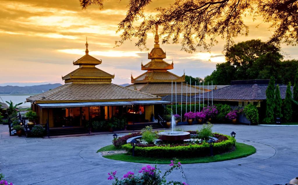 a building with two towers with a fountain in a garden at Bagan Thiripyitsaya Sanctuary Resort in Bagan