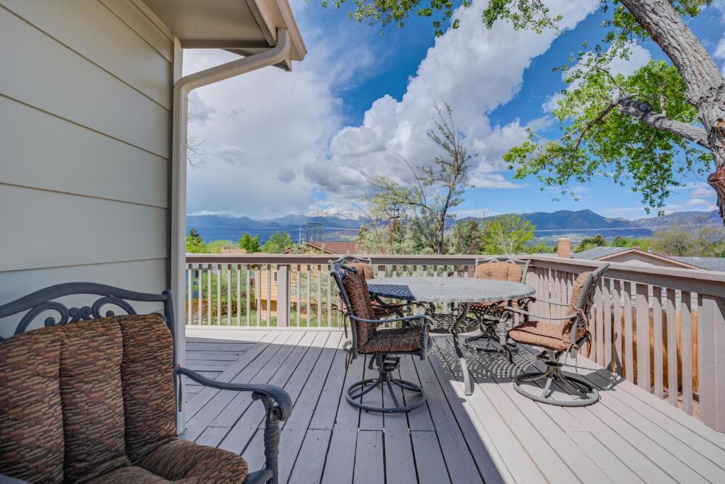 un patio con mesa y sillas en una terraza en Expansive Peak Views, 6BR House, Near USAFA, en Colorado Springs