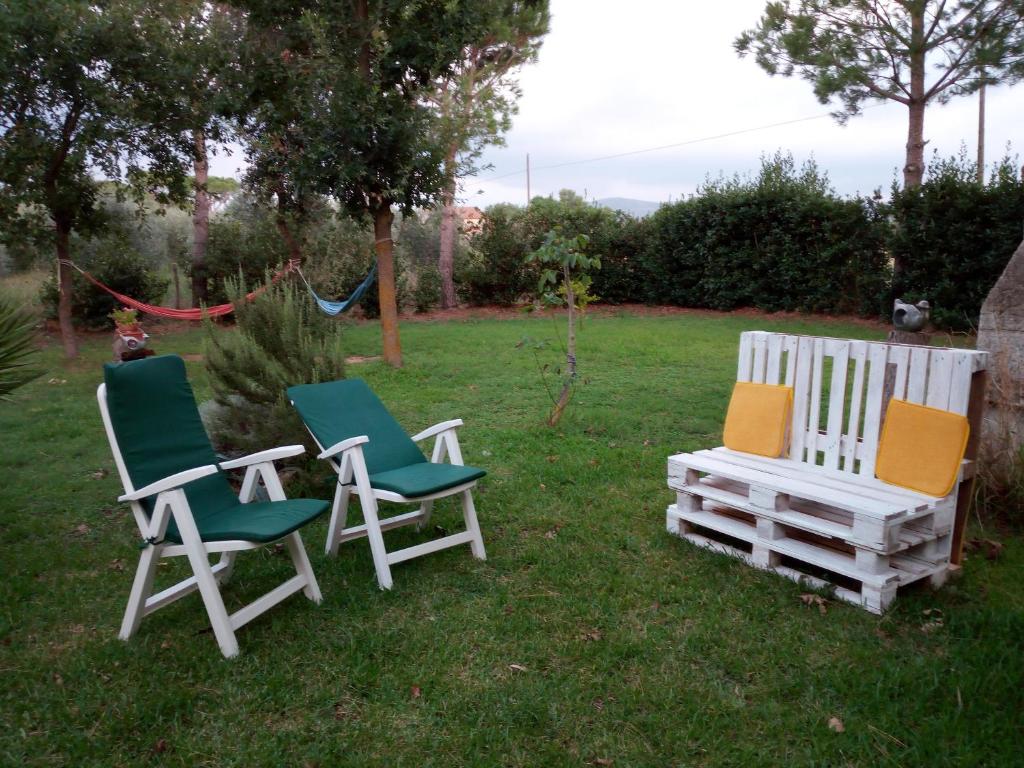 dos sillas y una mesa en el césped en Appartamento in Casale, en Rispescia