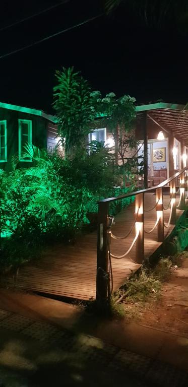 a wooden deck with lights on a house at night at Pousada Ventos da Atalaia in Fernando de Noronha