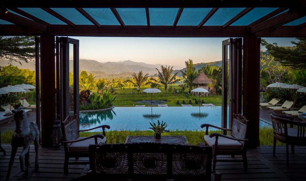uitzicht op een zwembad vanaf de veranda van een resort bij Sanak Retreat Bali in Munduk