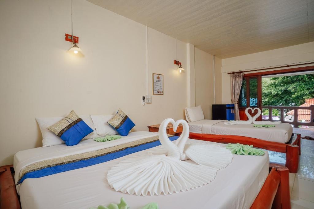 a room with two beds with swans on them at Paradise Bungalows in Haad Rin
