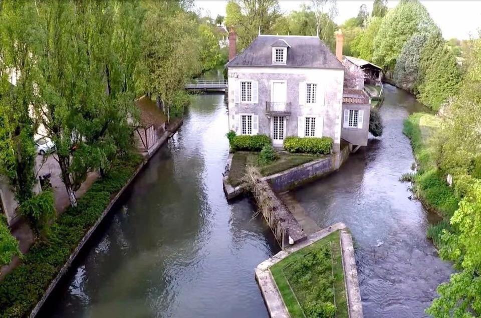 uma vista aérea de uma casa ao lado de um rio em Maison du Moulin em Donzy
