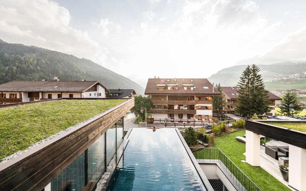 a hotel with a pool on the roof of a building at Biancaneve Family Hotel in Selva di Val Gardena
