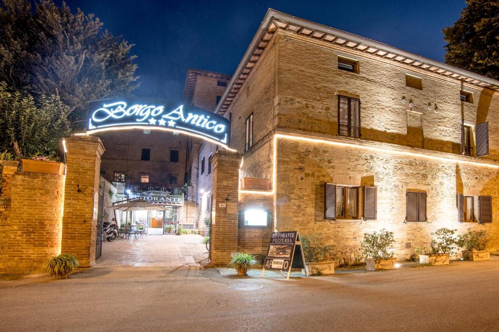 a large building with a clock on the front of it at Hotel Borgo Antico in Monteroni dʼArbia