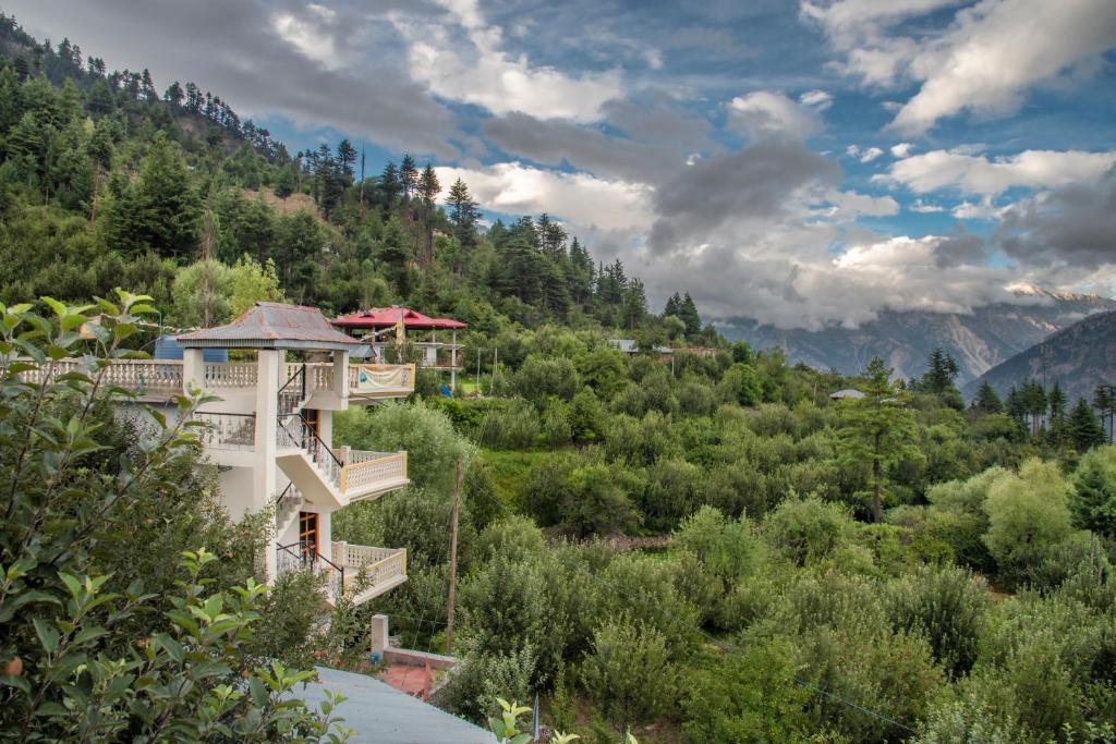 a house on a hill with trees and mountains at The Wild Trails by Livingstone in Kalpa