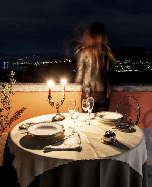 a table with plates and glasses and a candle on top at Hotel Locanda Dei Mai Intees in Azzate