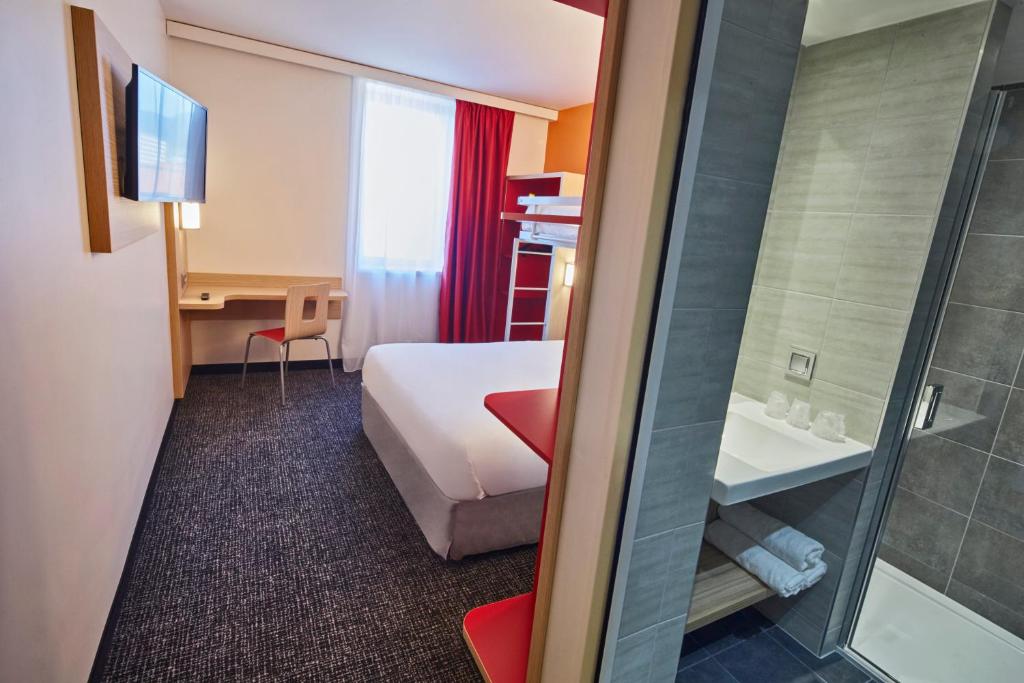 a hotel room with a bed and a shower at Premiere Classe Clermont Ferrand Centre in Clermont-Ferrand