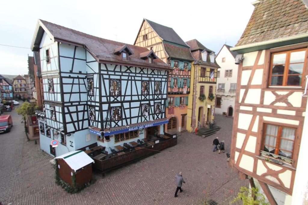 un viejo edificio en una ciudad con gente caminando por una calle en Chambre chez l'habitant - L Écureuil - Cœur de Riquewihr - 2 personnes en Riquewihr