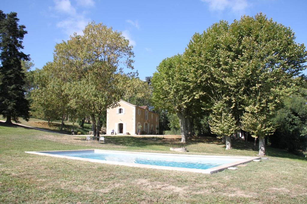 a swimming pool in front of a house with trees at La Ferme de Saint Christeau in Auch