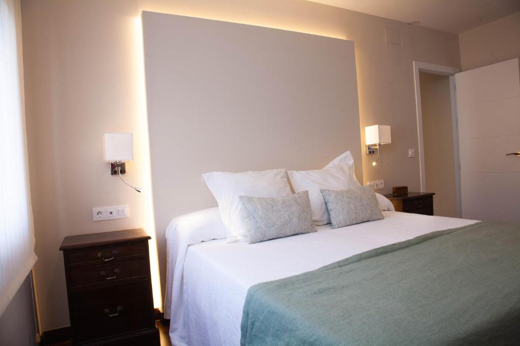um quarto com uma cama branca e 2 almofadas em Entrenaranjos em Córdoba