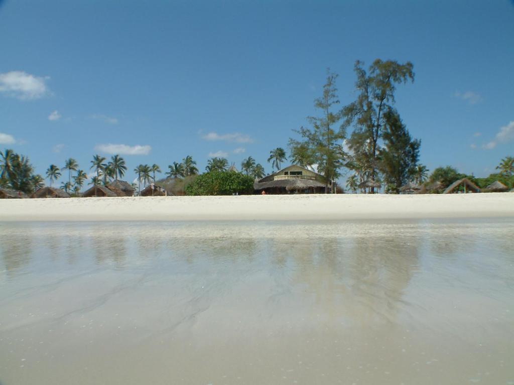 een uitzicht op een strand met een huis op de achtergrond bij Kipepeo Beach and Village in Dar es Salaam