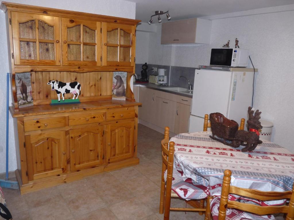 a kitchen with a cow on top of a wooden cabinet at L'étable in Crévoux