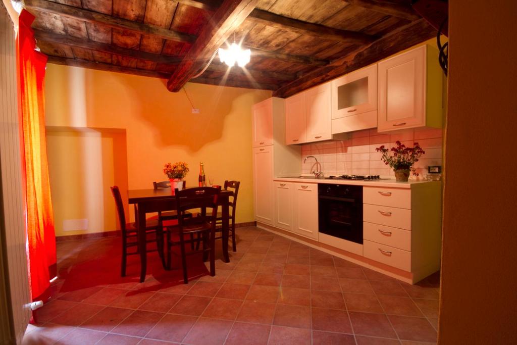 a kitchen with a table and chairs in a room at La Locanda Dei Cartunè in Montezemolo