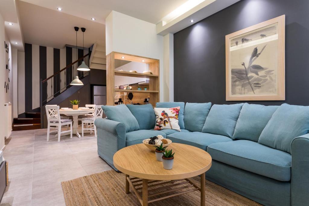 uma sala de estar com um sofá azul e uma mesa em modern city center maisonette em Ioannina