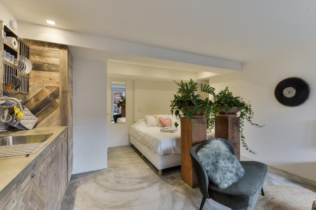 a bedroom with a bed and a chair and a sink at Luxury Beach Studio Zandvoort in Zandvoort