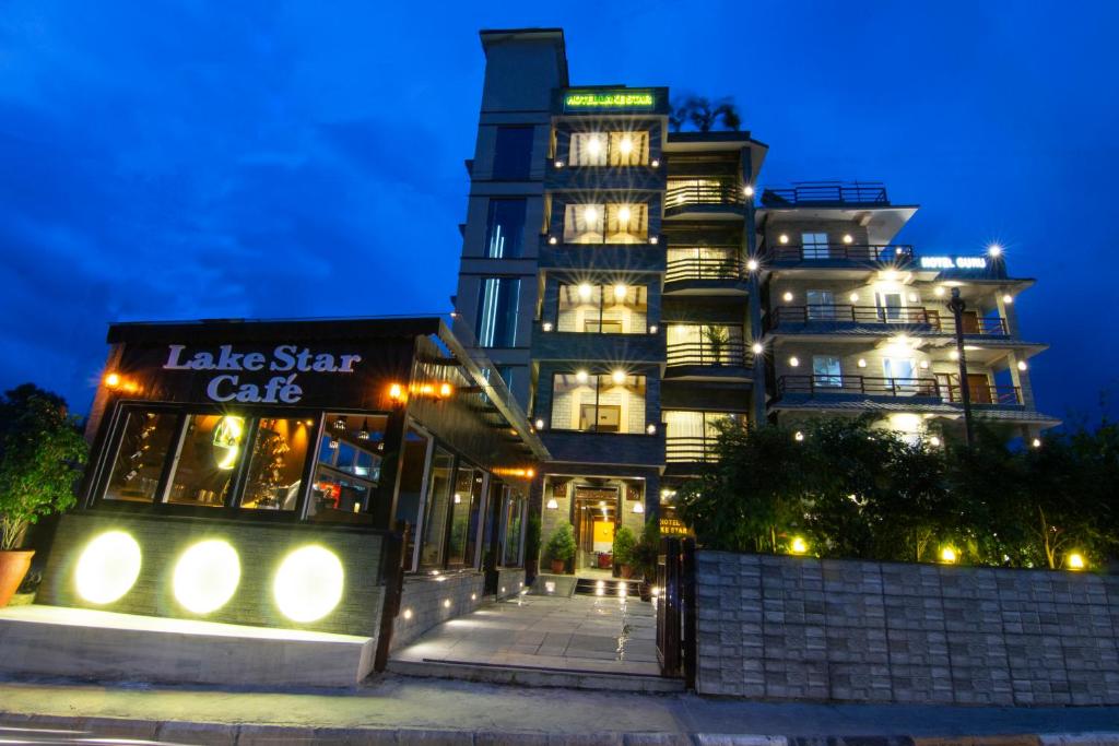 duży budynek z gwiezdną kawiarnią przed nim w nocy w obiekcie Hotel Lake Star w mieście Pokhara