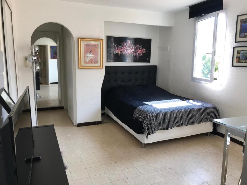 une chambre avec un lit au milieu d'une pièce dans l'établissement VOILES ST TROPEZ APARTEMENTS, à Saint-Tropez