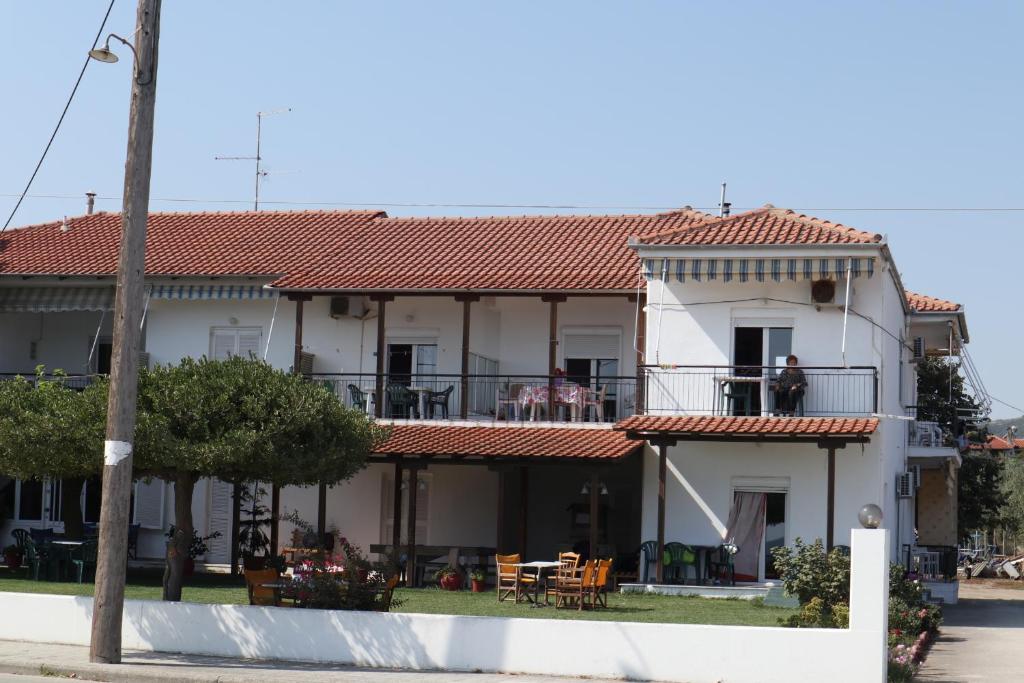 una gran casa blanca con techo rojo en Marilena Apartments Anastasiou, en Velika