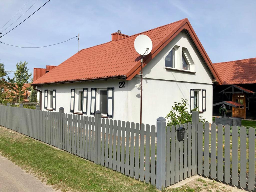 uma casa branca com uma cerca e um telhado vermelho em Plan Be Gałkowo em Gałkowo