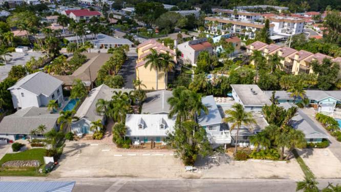 西耶斯塔島的住宿－Blue Sage，享有拥有房屋和棕榈树的城市的空中景致