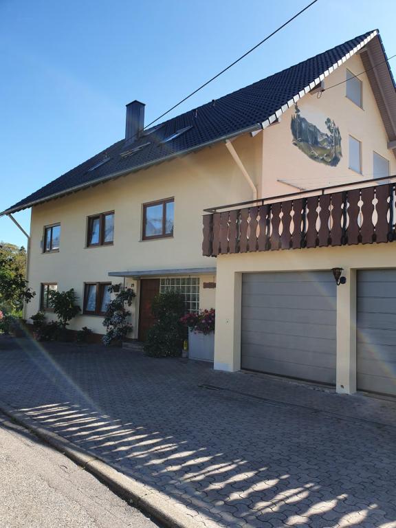 a house with two garage doors on a driveway at Chickenhill Blackforest, Ferienwohnung Großhans in Bad Wildbad