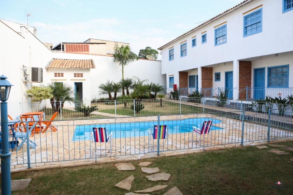 a swimming pool in front of a house at Rafa's Pousada Encantos de Minas in Três Corações