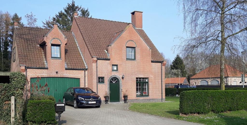 una casa con un coche aparcado delante de ella en Villa De Ruiter en Waasmunster