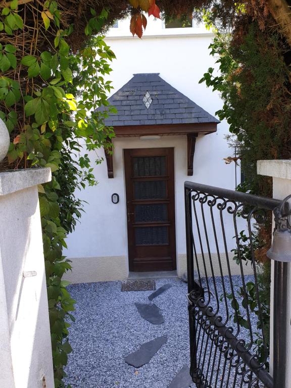 a gate leading to a white building with a door at Appartement T2 in Lau-Balagnas