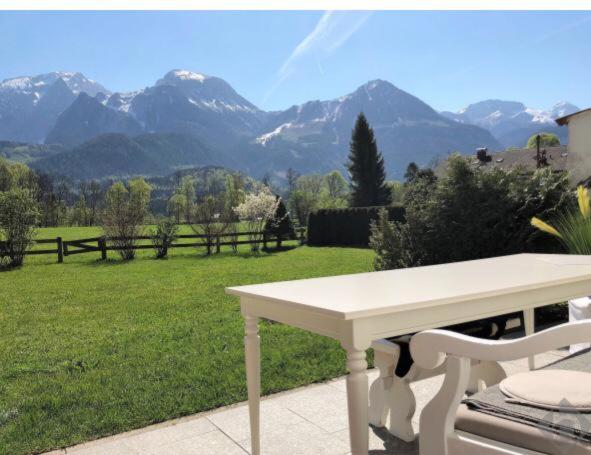 una mesa blanca en un patio con vistas a las montañas en Fewo Schönau am Königssee en Schönau am Königssee