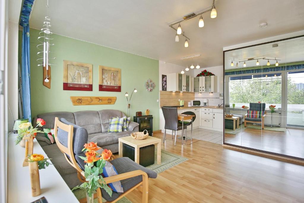 ein Wohnzimmer mit einem Sofa und einer Küche in der Unterkunft Küstenoase in Cuxhaven