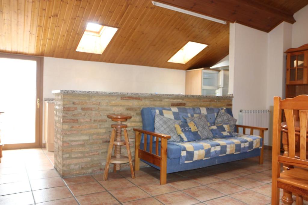 a living room with a blue couch and a stool at Hostal La Plaza in Puente la Reina