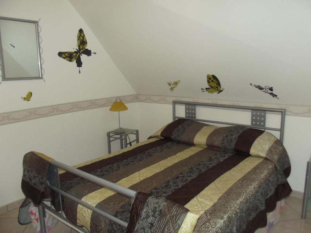 a bedroom with a bed with butterflies on the wall at APPARTEMENT WISSANT in Wissant