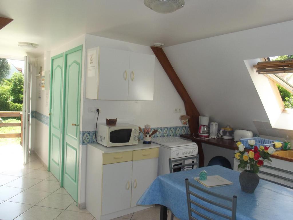 a small kitchen with a table and a microwave at APPARTEMENT WISSANT in Wissant