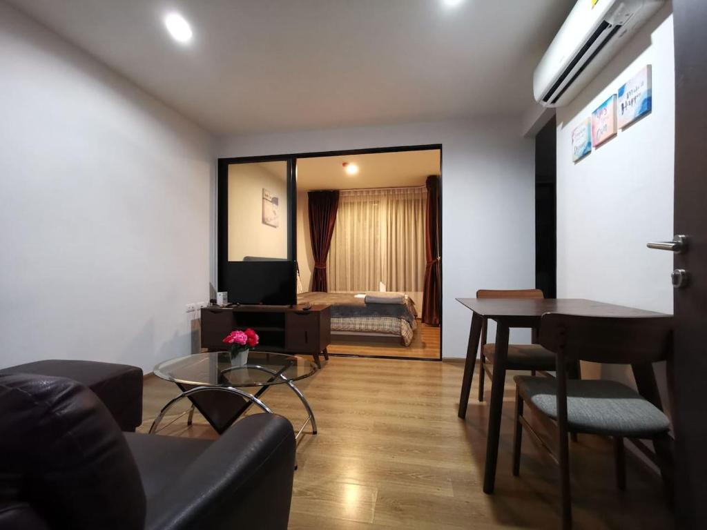 2 Floor - Centrio Condominium near Central Shopping Mall and Phuket Old town في فوكيت تاون: غرفة معيشة مع أريكة وطاولة وسرير