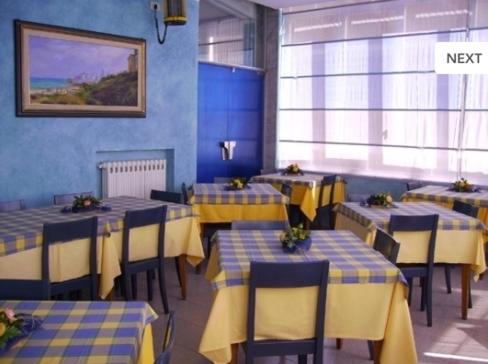 un restaurante con mesas y sillas amarillas y azules en Pensione Villa Ida, en Termoli