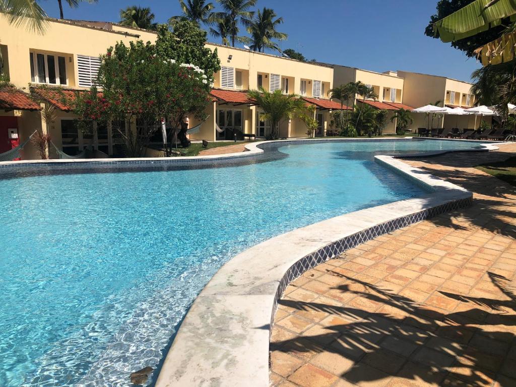 a swimming pool with blue water in a resort at Casa na Rua Principal - Pipa Atlântico in Pipa