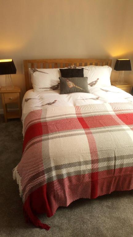 a bedroom with a bed with a red and white blanket at Haddington George House in Edinburgh