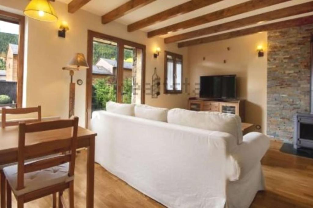 a living room with a white couch and a table at Peace & Rest in Pirineus in Latour-de-Carol