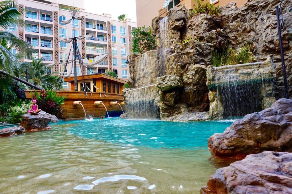 a swimming pool with a waterfall in a city at Atlantis Jomtien Waterworld Resort in Jomtien Beach