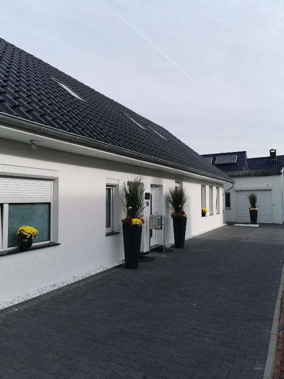 a white building with potted plants on the side of it at Apartments Margaretenhof in Wilhelmshaven